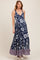 woman wearing a navy floral print maternity maxi dress with a pink patterned hem and visible baby bump