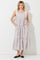 woman wearing a light pink floral maxi dress with adjustable tie straps and pockets