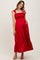 woman wearing a red maternity maxi dress with smocked bodice, ruffle details, and pockets, showcasing her baby bump