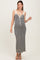 woman wearing a black and white striped maternity maxi dress with a tie front and spaghetti straps, showing off her baby bump