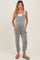 woman wearing a gray and white striped maternity romper with pockets and a visible baby bump