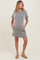 woman wearing a striped maternity dress with short sleeves and pockets, showcasing her baby bump