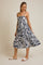woman wearing a navy and white abstract print tiered midi dress with spaghetti straps and sandals