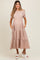 woman wearing a pink maternity dress with short puff sleeves and pockets, featuring a tiered skirt and visible baby bump
