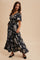 woman wearing a navy blue floral maxi dress with a v-neckline and short sleeves