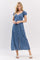 woman wearing a blue polka dot maxi dress with short puff sleeves and a front slit