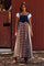woman wearing a long denim and plaid maxi overall dress with buttons, paired with a white t-shirt and brown boots