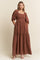 woman wearing a brown puff sleeve maxi dress with floral embroidery and a square neckline