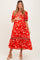 woman wearing a red floral maternity dress with puffed sleeves and tiered skirt, holding her baby bump