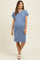 woman wearing a blue striped maternity dress with short sleeves and a chest pocket, displaying her baby bump