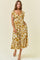 woman wearing a white floral midi dress with ruffle details and pockets, standing against a light background