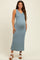 woman wearing a ribbed blue maternity maxi dress with a side slit and showing her baby bump