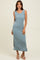 woman wearing a light blue ribbed maxi dress with side slits and a scoop neckline