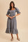 woman wearing a blue and white gingham midi dress with puff sleeves and a tiered hem