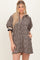 woman wearing a short leopard print dress with a zip-up collar and puff sleeves, featuring side pockets