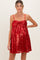 woman wearing a red sequin maternity dress with a bow detail and adjustable spaghetti straps, showing baby bump