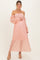 woman wearing a peach off-the-shoulder lace maternity dress and holding her baby bump