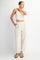 woman wearing a light beige cropped tank top and matching wide-leg pants with pockets