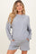 woman wearing a gray maternity sweatshirt and matching shorts with pockets, showing a baby bump