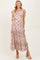 woman wearing a floral maxi maternity dress with ruffles and a v-neck, highlighting her baby bump