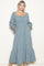 woman wearing a blue and white checkered long sleeve maxi dress with a square neckline and pockets