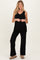 woman wearing a black ribbed maternity tank top and matching pants, showing her baby bump