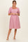 woman wearing a pink and white striped maternity dress with puff sleeves and a square neckline