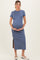 woman wearing a blue maternity midi dress with a side slit and holding her baby bump