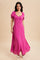 woman wearing a bright pink button-up maxi dress with puff sleeves and a flowy skirt