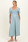 woman wearing a light blue maternity jumpsuit with puff sleeves and a fitted bodice, holding her baby bump