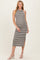 woman wearing a gray and white striped maternity midi dress with a halter neck and side slit, showcasing her baby bump