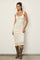 woman wearing a fitted cream-colored midi dress with ruffled straps and lace details, paired with brown cowboy boots