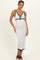 woman wearing a white maternity dress with black trim and a tie detail, displaying her baby bump