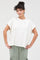 woman wearing a loose-fitting cream short sleeve t-shirt and light green cargo pants