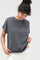 woman wearing a dark gray oversized t-shirt with rolled sleeves and a relaxed fit