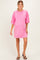 woman wearing a pink oversized maternity dress with short sleeves and a round neckline, showing a baby bump