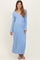 woman wearing a light blue striped maternity maxi dress with a v-neck and wrap styling, showcasing her baby bump
