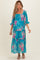 woman wearing a teal floral maternity maxi dress with smocked bodice and tiered ruffle sleeves