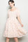 woman wearing a pastel floral print dress with puff sleeves and a square neckline