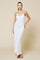 woman wearing a white halter neck maxi dress with a textured fabric and a fitted silhouette