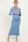 woman wearing a light blue ribbed maternity dress with long sleeves and ruffle hem, showing her baby bump