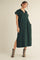 woman wearing a dark green short sleeve collared maxi dress with side pockets and slit, paired with gray ankle boots