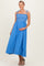 woman wearing a blue maternity maxi dress with smocked bodice and tie straps, holding her baby bump