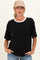 woman wearing a black short sleeve maternity top with a white collar and holding her hands in the pockets of her jeans