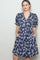 woman wearing a navy floral print puff sleeve dress with pockets and a v-neckline