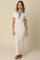 woman wearing a cream-colored maxi dress with a denim collar and short sleeves