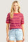 woman wearing a red and blue striped short sleeve t-shirt with cuffed sleeves and light blue denim shorts