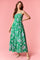 woman wearing a green floral maxi dress with a smocked bodice and spaghetti straps