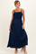 woman wearing a navy blue maternity maxi dress with smocked bodice and spaghetti straps, showcasing her baby bump