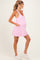 woman wearing a pink maternity dress with pockets and a v-neck, showing her baby bump
